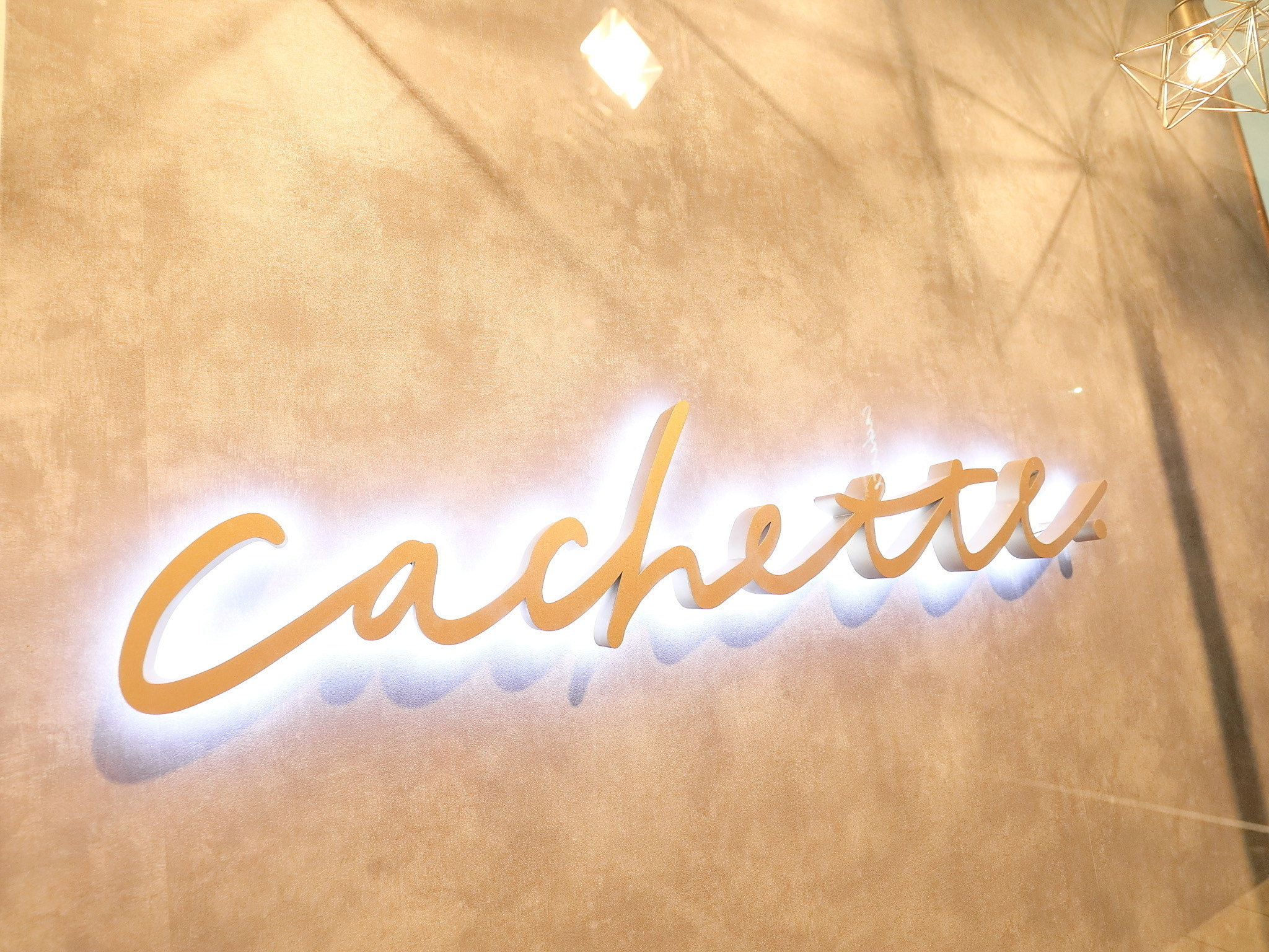 店内の壁に掲げられた cachette のサイン